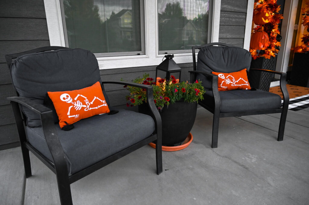 Fall porch seating with Halloween pillows and lanterns